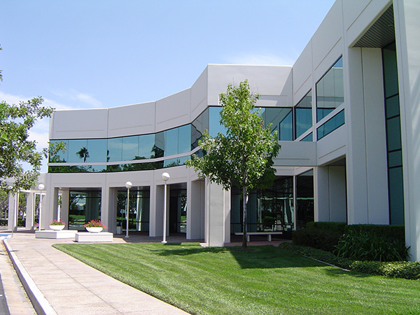 a white commercial building with many glass windows