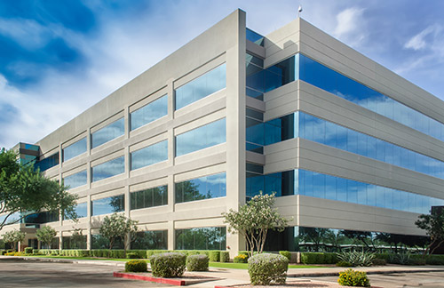 An image of a cream-colored commercial building with lots of windows.