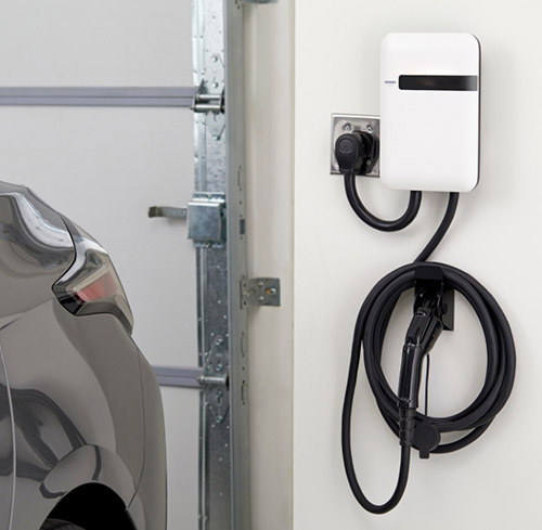 A photo of an electric car charger installed in a home garage.