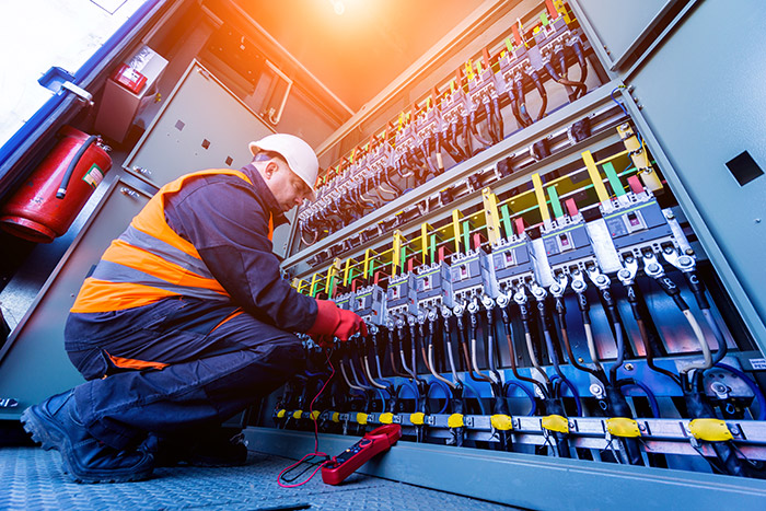 industrial electrician working to install electrical service or solve electrical problems in an industrial setting