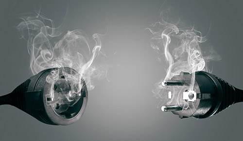 An image of a smoking electrical plug and a socket
